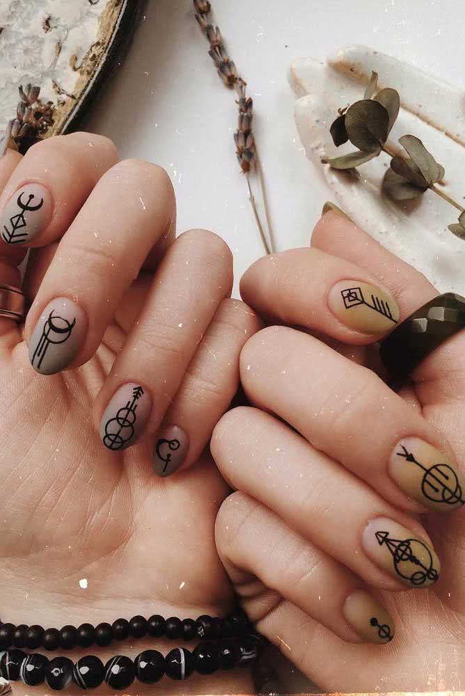 Unhas decoradas para o ano novo com símbolo dos planetas. Em uma mão, as unhas ganharam fundo prata e na outra, fundo dourado