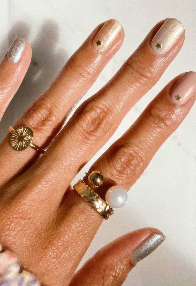 Unhas simples para o ano novo. Aqui bastou o esmalte dourado e a aplicação das estrelinhas rentes com a cutícula 