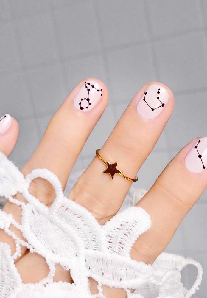 Mas se você é uma noiva com uma forte conexão com as estrelas, confira essa ideia de unhas brancas com desenhos de constelações em preto nas unhas