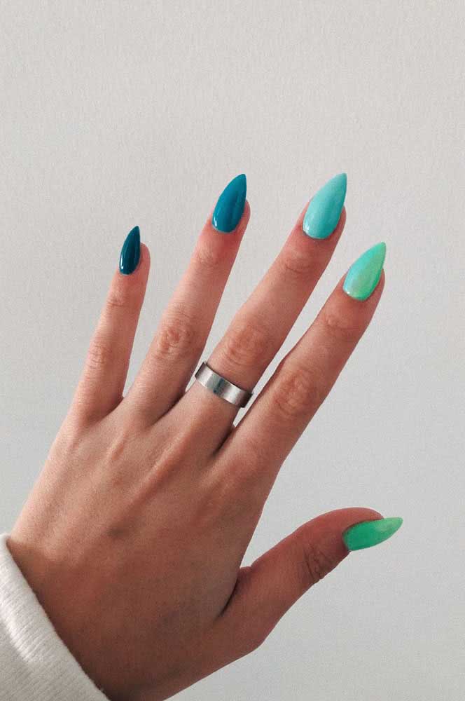 Inspire-se no mar e aposte em um degradê de tons de azul piscina e verde furta cor nas suas unhas stiletto. 