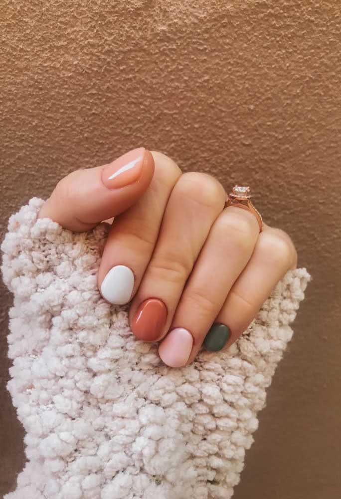 Unhas multicoloridas degradê de rosa e um toque de verde acinzentado. 