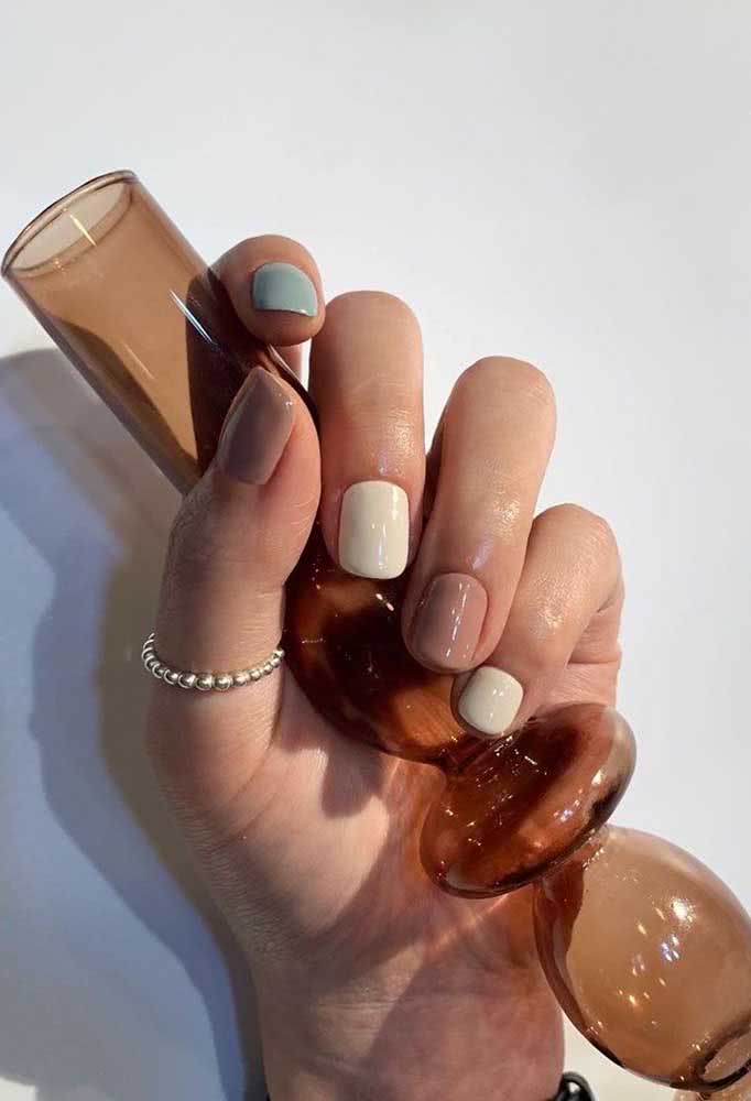 Outra ideia super elegante de unhas multicoloridas usando nude, branco e um tom de azul claro.