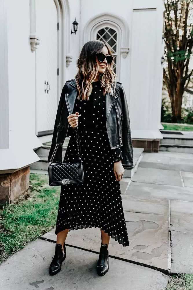 Looks onde o preto é predominante ganham mais profundidade e estilo quando são incorporadas peças com textura ou estampa, como o caso deste vestido preto de botinhas e da bota adornada com rebites.