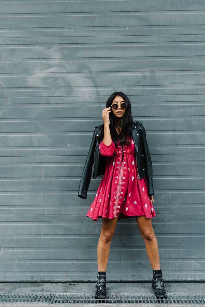 Vestido rosa levinho com jaqueta de couro e bota preta para arrasar num estilo rocker. 