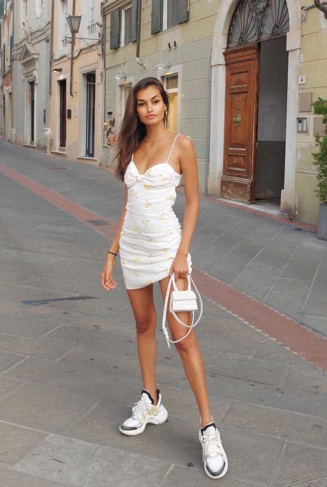 Vestido curto de alcinha com dad sneakers, uma combinação perfeita no estilo Hi-Lo, uma tendência na moda. 