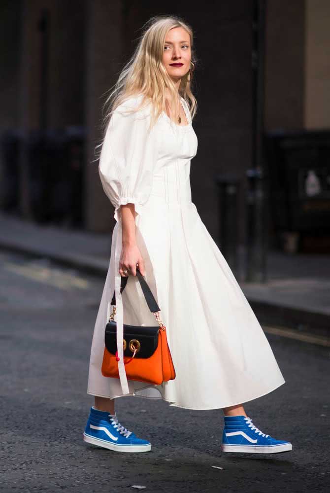 Vestido branco midi com mangas bufantes ganha ainda mais personalidade com um tênis azul anil. 