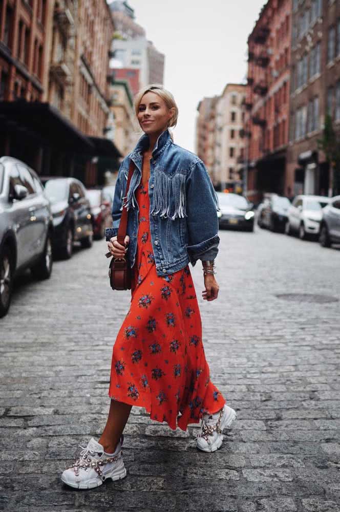 Já para um visual fashionista, uma combinação de arrasar com vestido midi floral, jaqueta jeans larga e dad sneakers brancos.