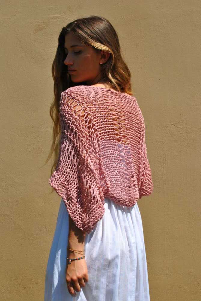 Esse bolero de crochê rosa cai sobre os ombros feito um xale e é a combinação perfeita para usar com um vestido branco leve e criar um look romântico.