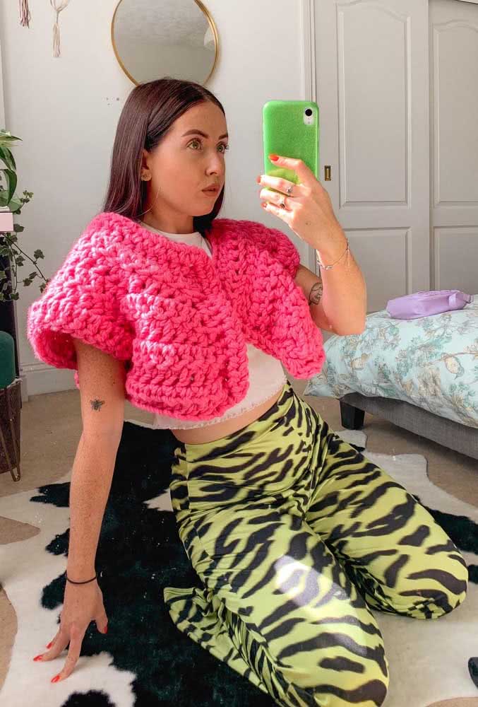 Mas se você quer adicionar um toque de ousadia no seu visual, aposte nesta combinação de bolero de crochê rosa neon bem volumoso com legging animal print verde. 