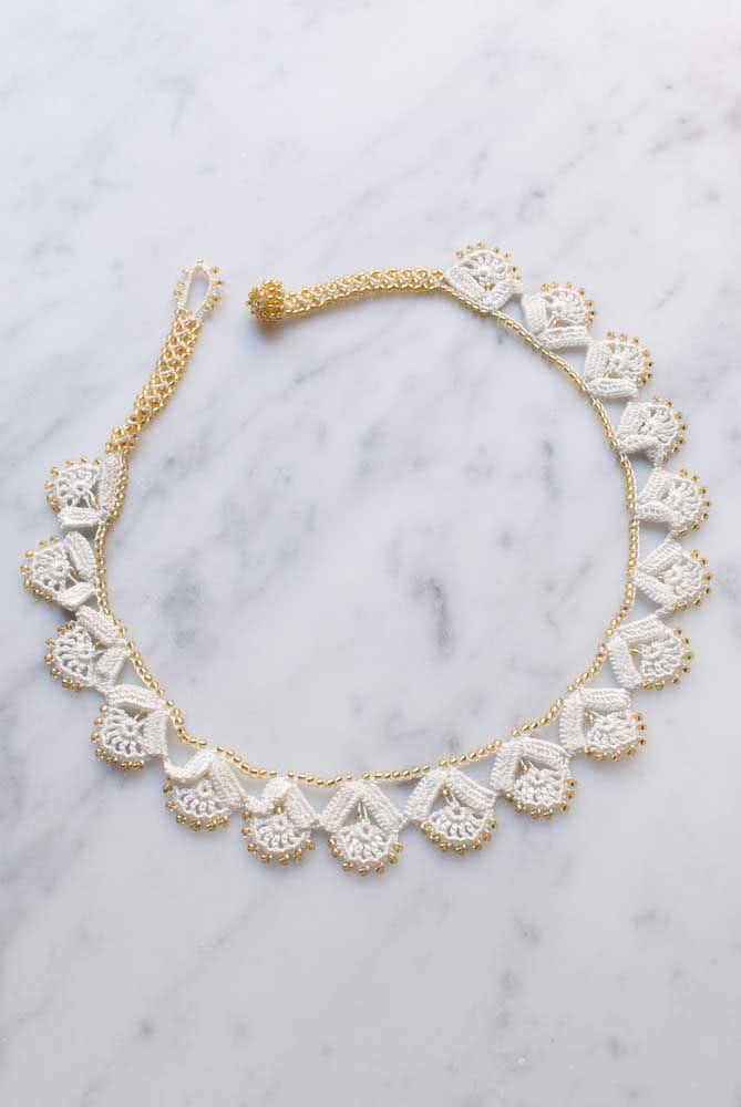 Composto por fios branco e dourado, esse colar de crochê aposta na sofisticação 
