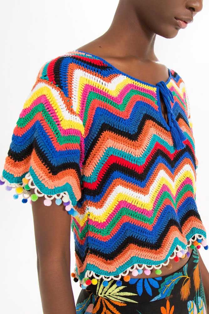 E por falar em colorido, confira esse modelo de cropped de crochê bem soltinho feito em padrão chevron e com aplicação de pomponzinhos na barra.