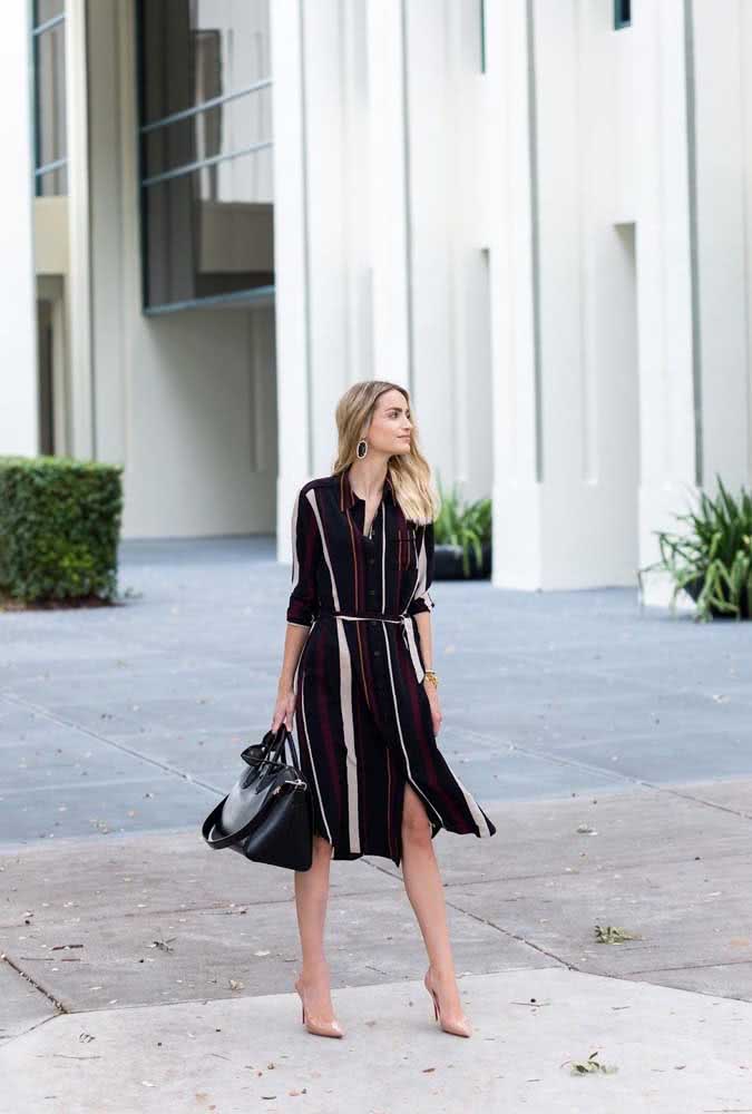 Um look trabalho leve e estiloso, mas sem deixar a formalidade com vestido chemise preto, com listras bordô, branco e mostarda, bolsa preta e um scarpin nude. 