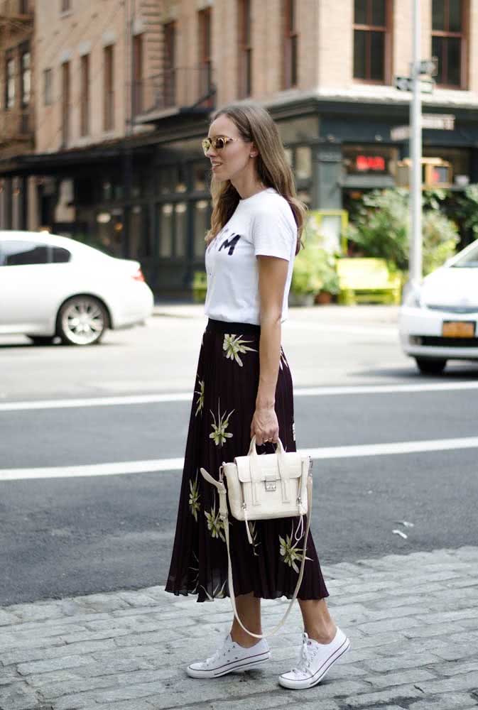 Camiseta branca, saia midi preta floral e all star formam um look trabalho informal, fresco e confortável.