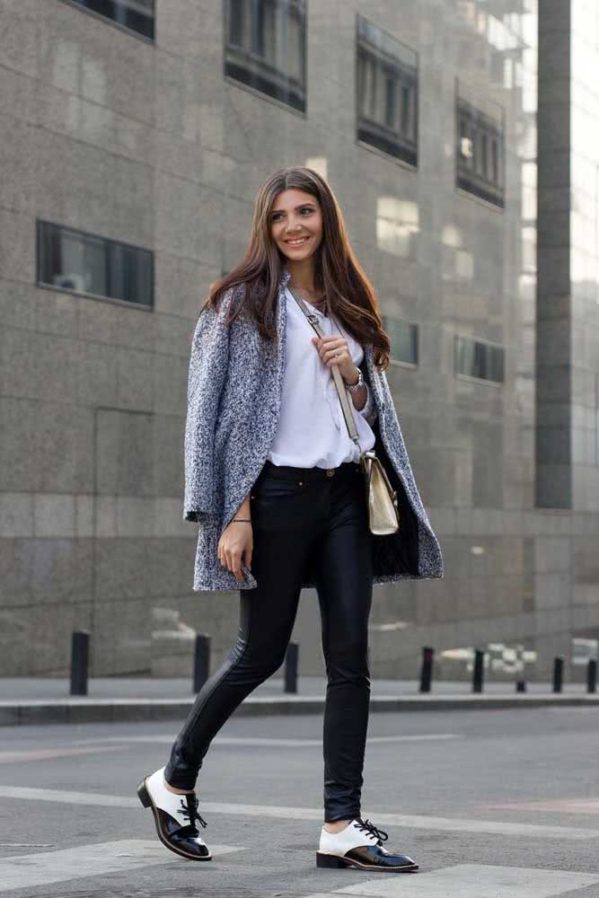 Look de trabalho preto e branco com camisa branca, calça skinny preta, sapato oxford e um blazer com padronagem que reúne as duas cores.