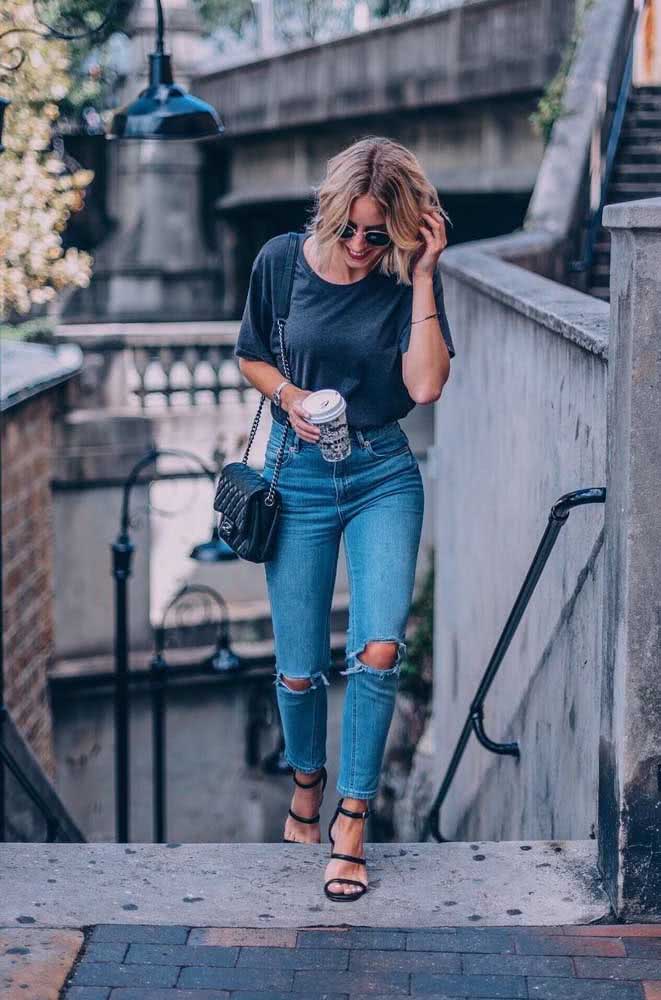 Calça mom jeans destroyed com T-shirt grafite e sandália de tiras, um look simples e super despojado para usar em ambiente informais.