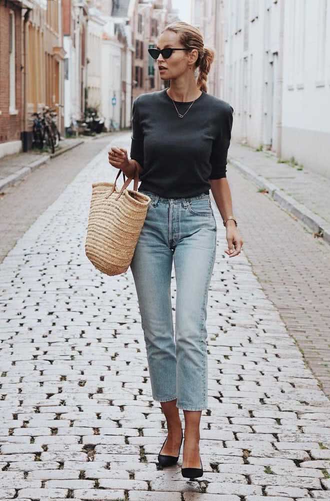Para trabalhar ou passear pela cidade num dia de sol, uma combinação de mom jeans em lavagem clara, blusa preta com manga média e scarpin na mesma cor.