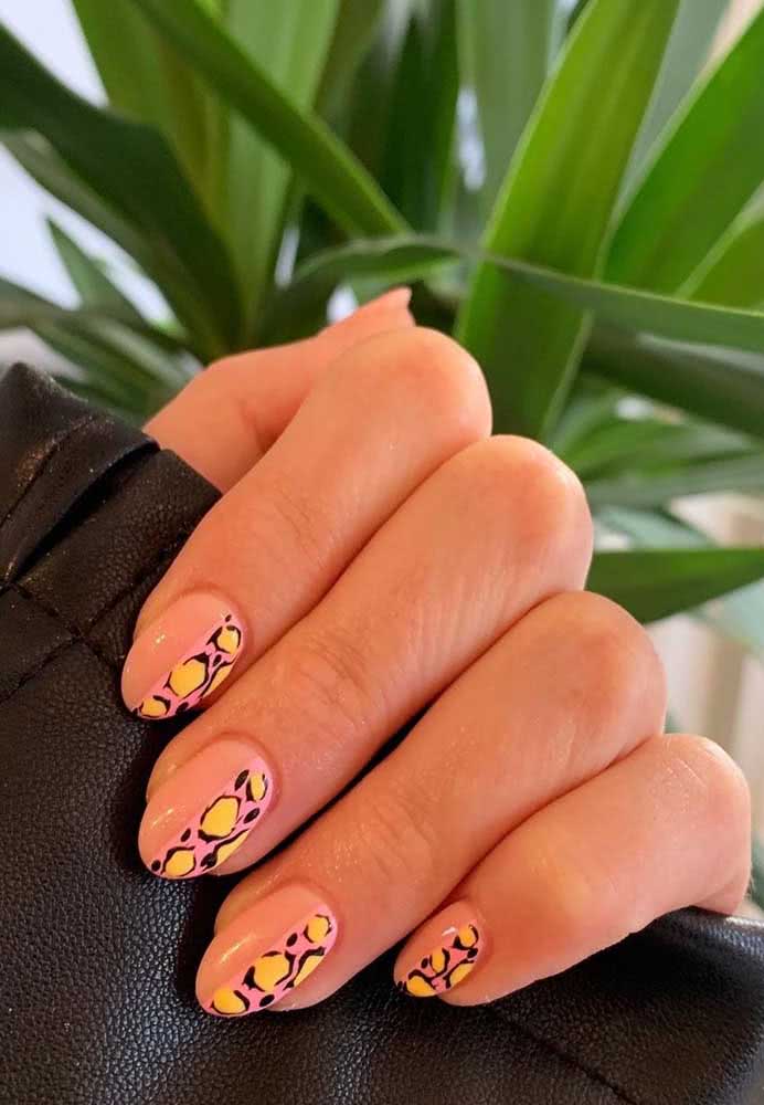 Inusitada, essas unhas de oncinha mesclam o fundo rosa com manchas amarelas