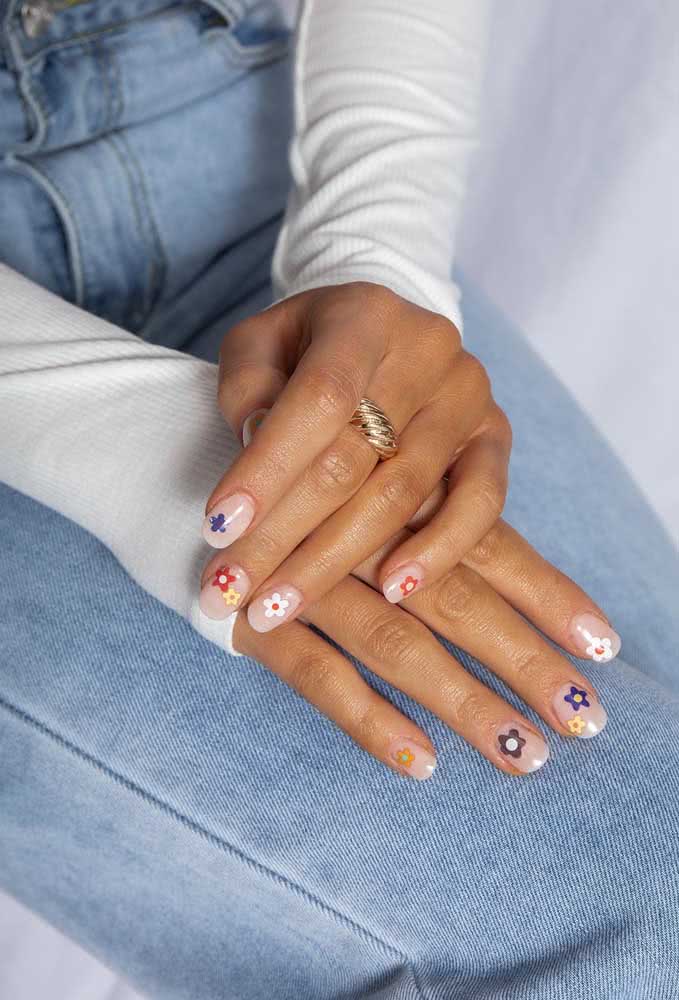 Unhas decoradas com flores delicadas, mas com um toque de cor alegre e descontraído 