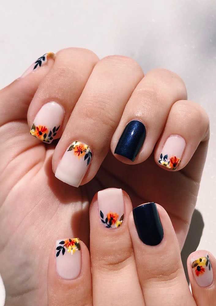 Unhas decoradas com flores delicadas, mas com um toque de sofisticação graças ao esmalte preto