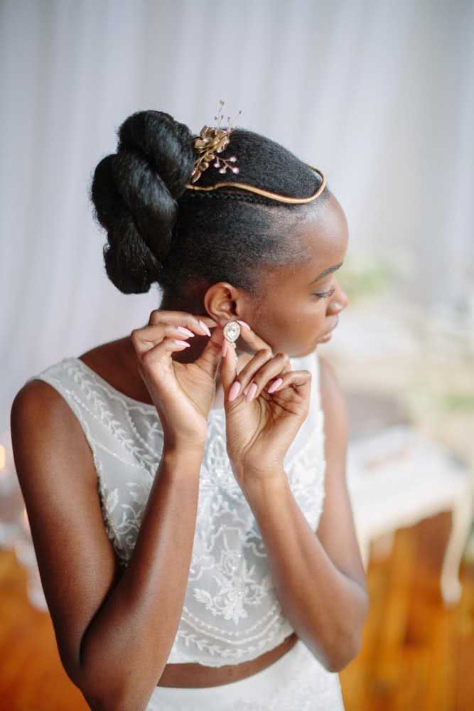 Cabelo preso para noiva com arranjo dourado para completar o penteado afro