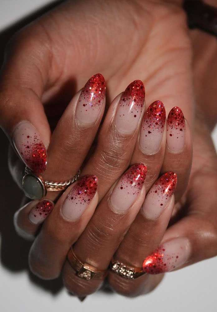 Unhas com glitter vermelho. Para aumentar o contraste, use um esmalte de cor clara na base