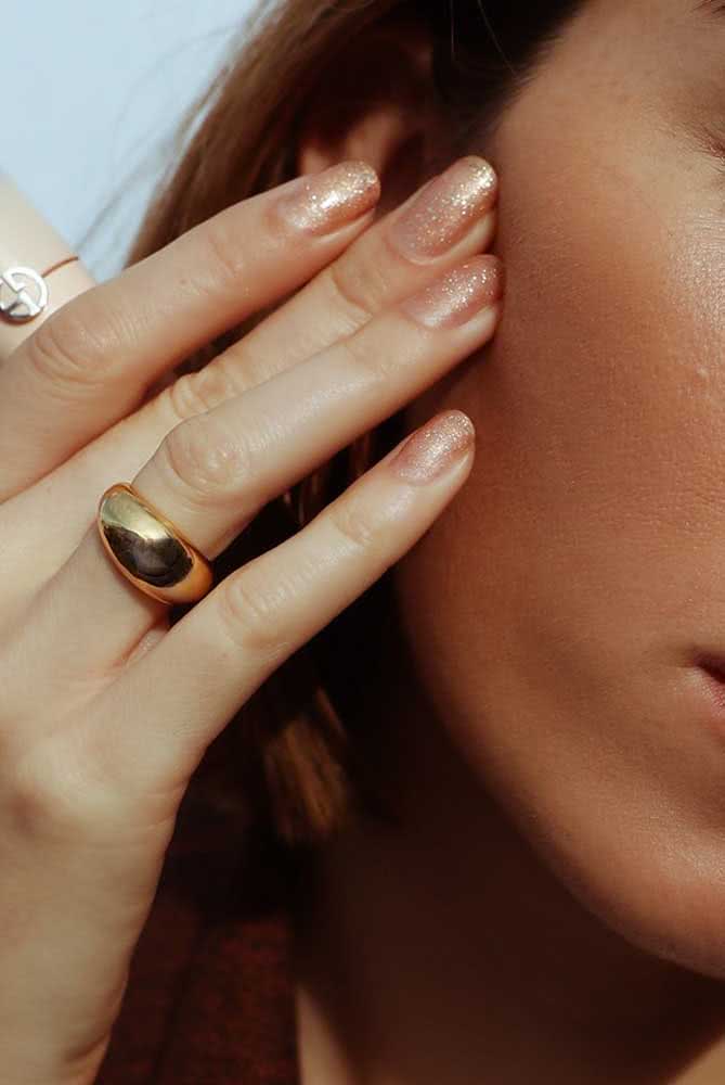 Unhas com glitter dourado para combinar com a cor bronzeada do verão