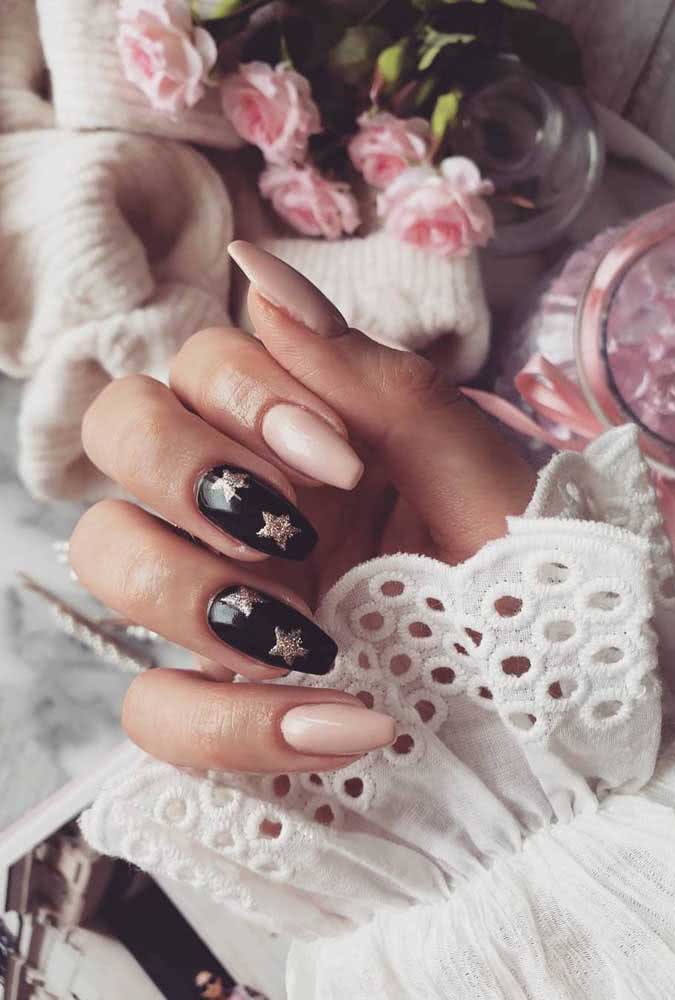 Unhas gêmeas em preto com estrelas douradas formam a combinação perfeita com o rosa claro 