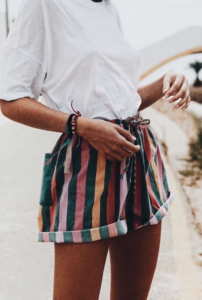 Os shorts de tecido estampados e multicoloridos trazem um toque leve e divertido para os looks veranis. 