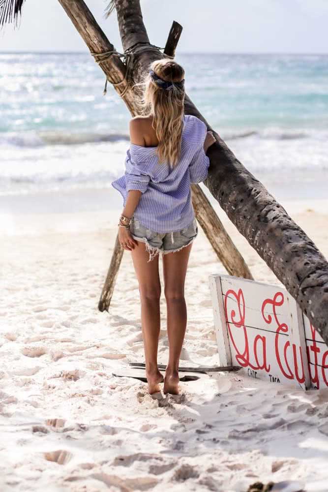 Despojado e versátil, a combinação de shorts jeans desfiado e camisa é coringa para criar um look praia no momento. 