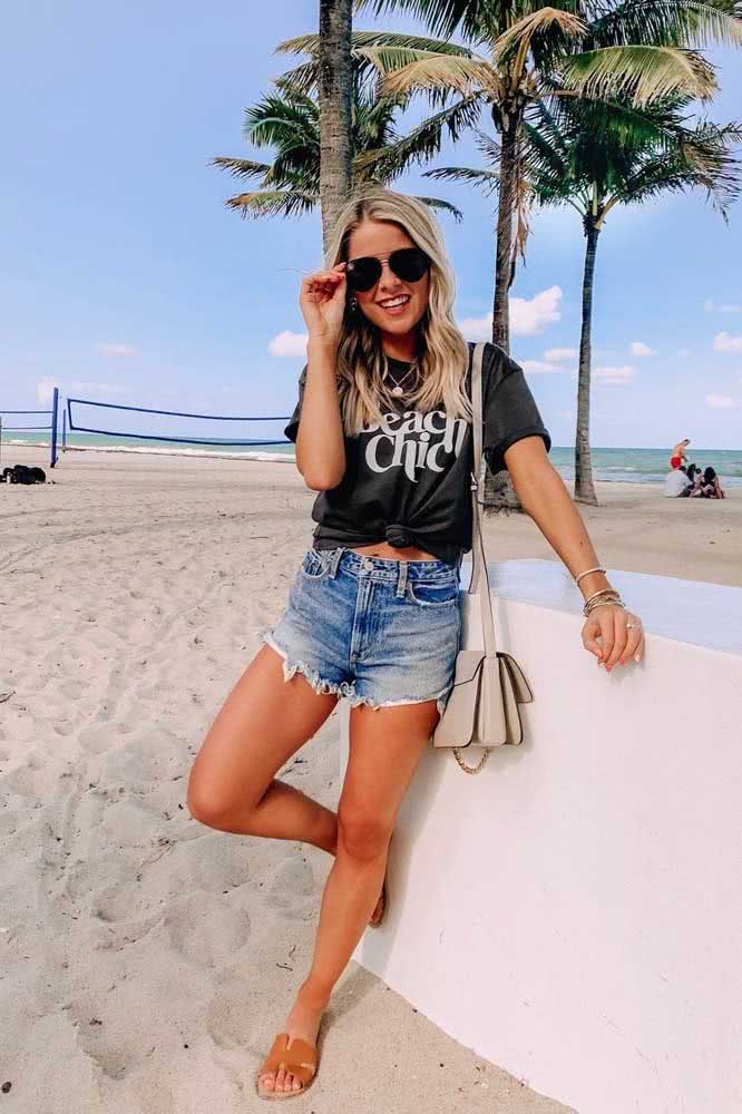 Outra opção para um look de praia despojado com shorts jeans são as camisetas amarradas. 