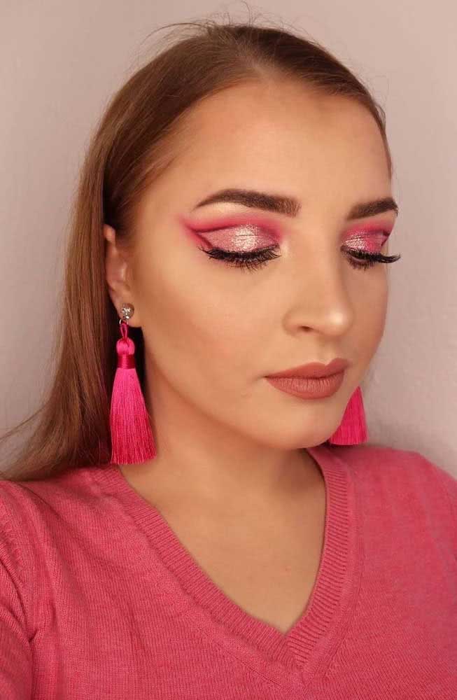 Perfeita para um maquiagem rosa festiva, uma sombra rosa clara com glitter contornada com rosa pink.