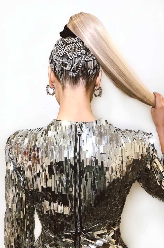 Um penteado simples e que grita atitude com rabo de cavalo alto com um scrunchie de veludo e presilhas prateadas diversas na nuca.