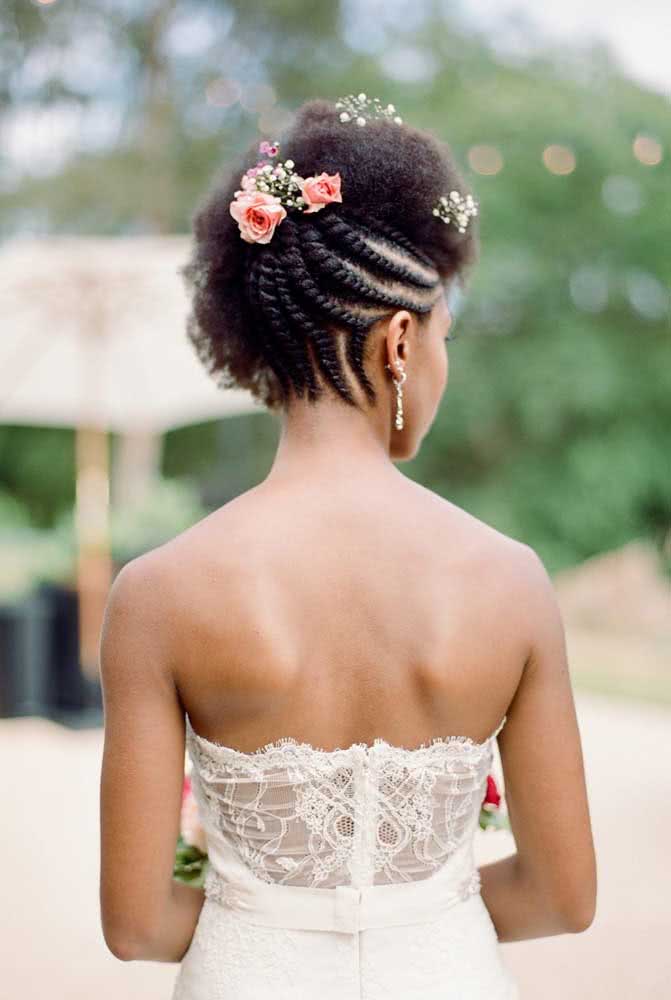 As rope braids embutidas na lateral traseira deste penteado para cabelo crespo trazem texturas diferentes para este penteado simples e a adição de flores o torna ainda mais delicado e romântico.