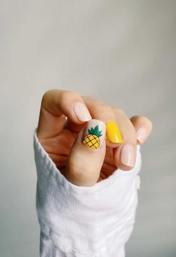 Divertido e jovial, unhas delicadas com composição em branco e amarelo, com um abacaxi desenhado para completar.
