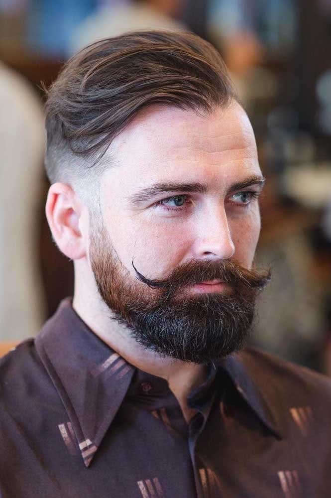 Muito estilo com corte mid fade com franja longa e degradê também na barba.