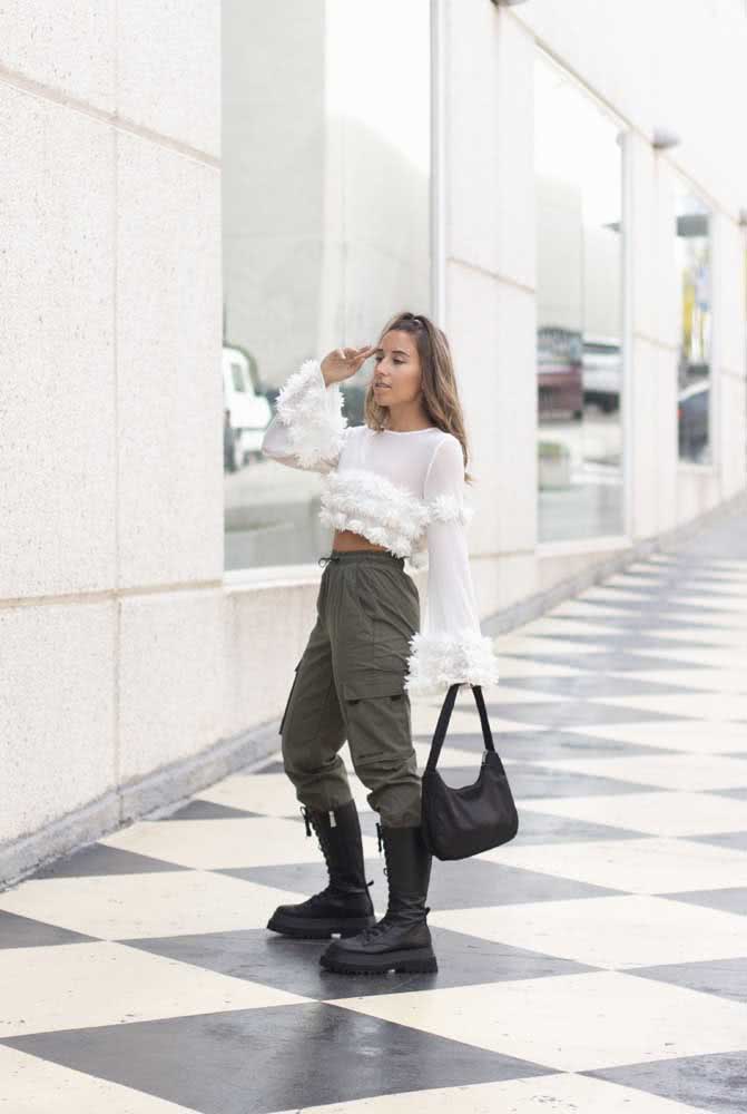 Já para quem quer ousar no estilo hi-lo, uma combinação com blusa branca com pompons, calça cargo verde oliva e um coturno de cano longo. 