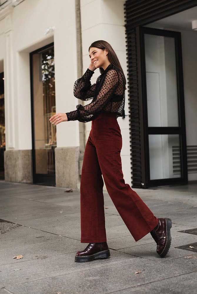 E para arrasar nas festas, um look com coturno e calça wide leg vermelha e camisa preta com transparência.