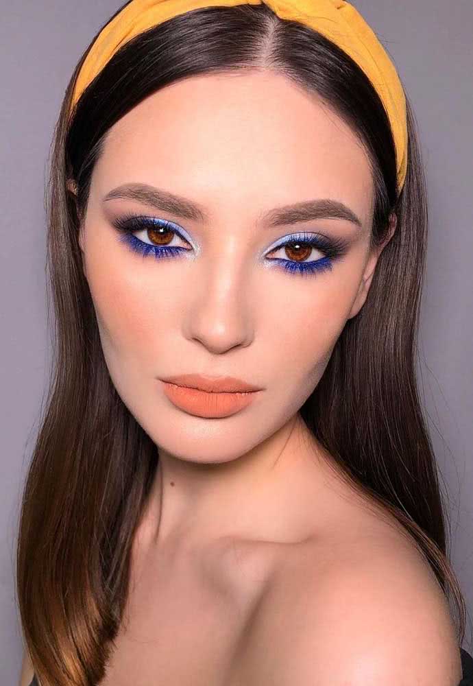 Maquiagem tumblr com batom matte e blush pêssego e sombra azul claro na pálpebra e royal na parte inferior do olho, com cílios extensos e bem escovados.