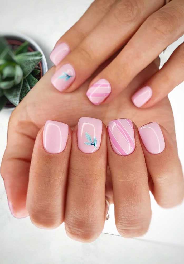 Mas para um toque delicado, experimente essa composição de unhas decoradas rosa bebê com uma filha única listrada e outra com aplicação de uma folhinha em adesivo.