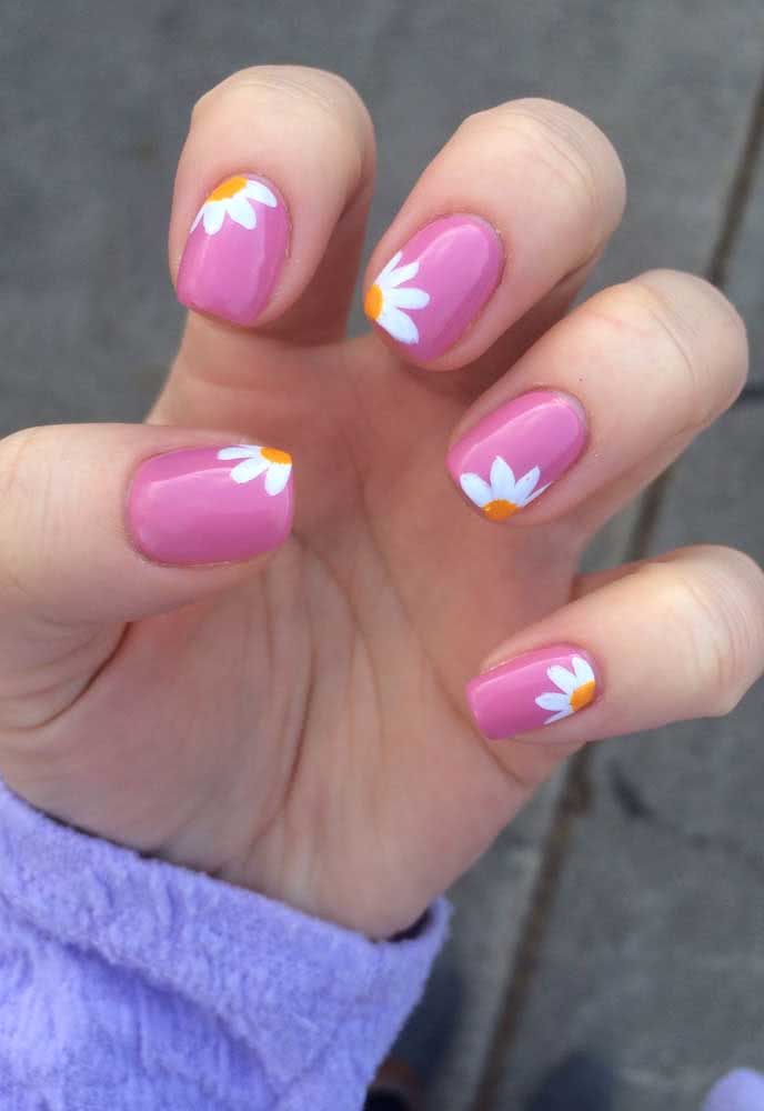 Divertido, jovem e super fácil de fazer, uma composição de unhas decoradas rosa com margaridas.