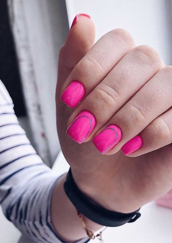 Um contorno fino com glitter nas unhas gêmeas traz um elemento a mais para estas unhas decoradas rosa pink.