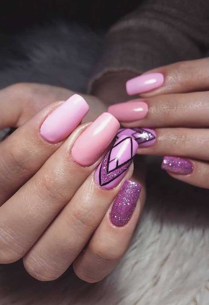Unhas decoradas rosa claro com dois destaques: glitter e um grafismo feito com esmalte preto.
