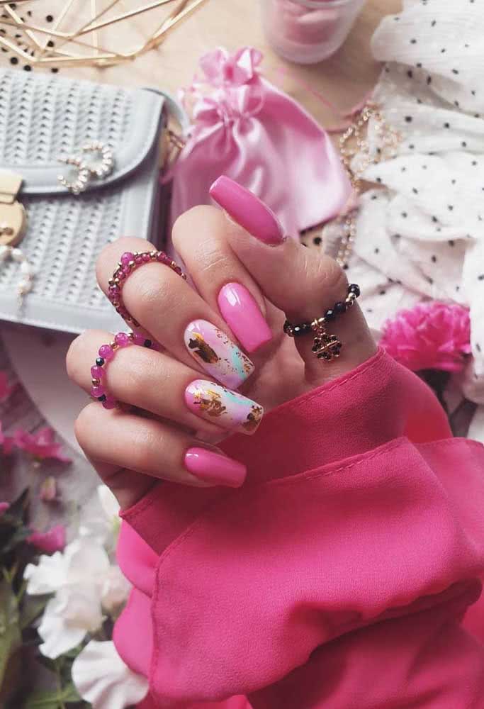 Unhas gêmeas em rosa claro com toques de azul e dourado formam a combinação perfeita com o pink nas outras unhas.