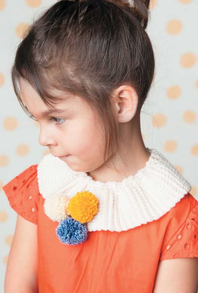 As golas de crochê são ótimas formas de personalizar blusas infantis, como é o caso desta branca que vem acompanhada por três pompons na parte frontal.