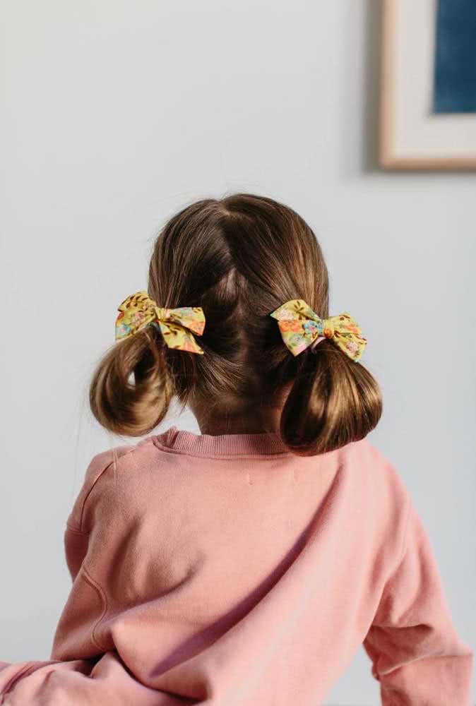 A maria-chiquinho é um clássico penteado para criança, que neste exemplo ganha um toque a mais com laços de tecido e os fios dobrados no comprimento.