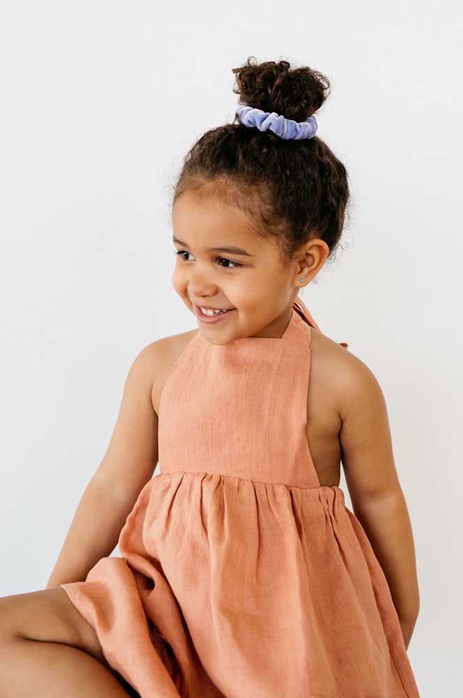Os scrunchies (também conhecidos como fru-frus) voltaram com tudo na moda e são outra forma simples de prender um coque alto em criança com muito estilo.