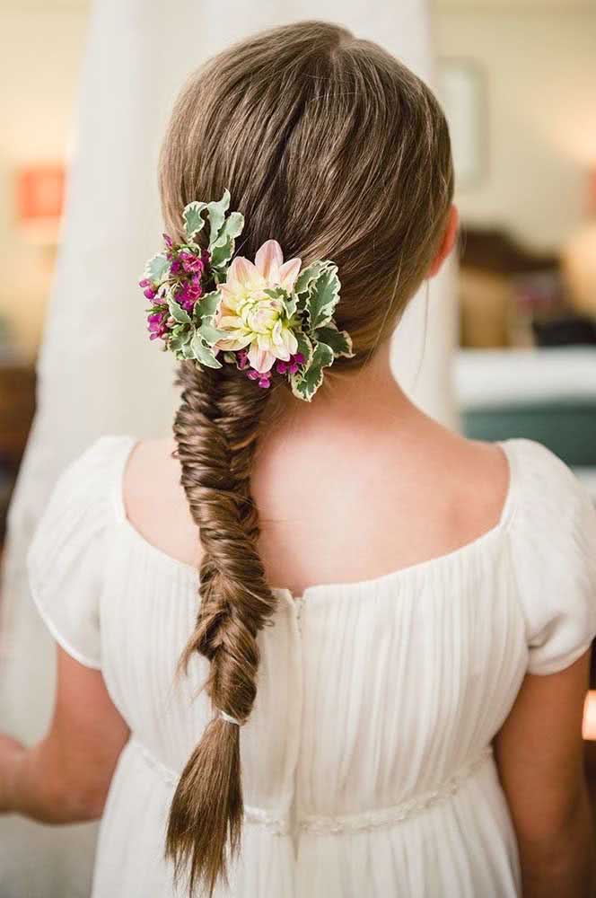 A trança espinha de peixe requer um pouco mais de habilidade para fazer, mas o resultado é um penteado lindo para criança, que neste caso ganha a adição de um arranjo de flores. 