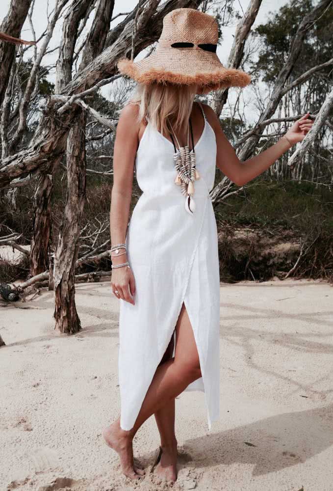 Vestido branco com fenda frontal como uma saída de praia perfeita para quem busca uma inspiração no estilo boho.