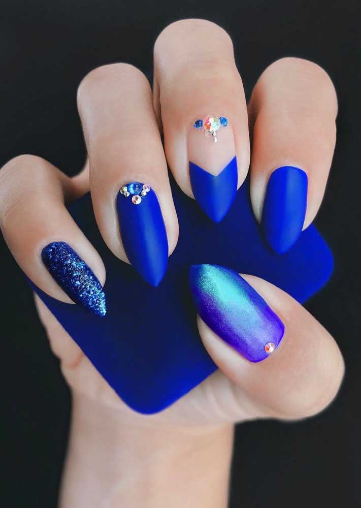 As pedras aplicadas trazem mais estilo à esta nail art assimétrica, com decorações diferentes em cada unha.