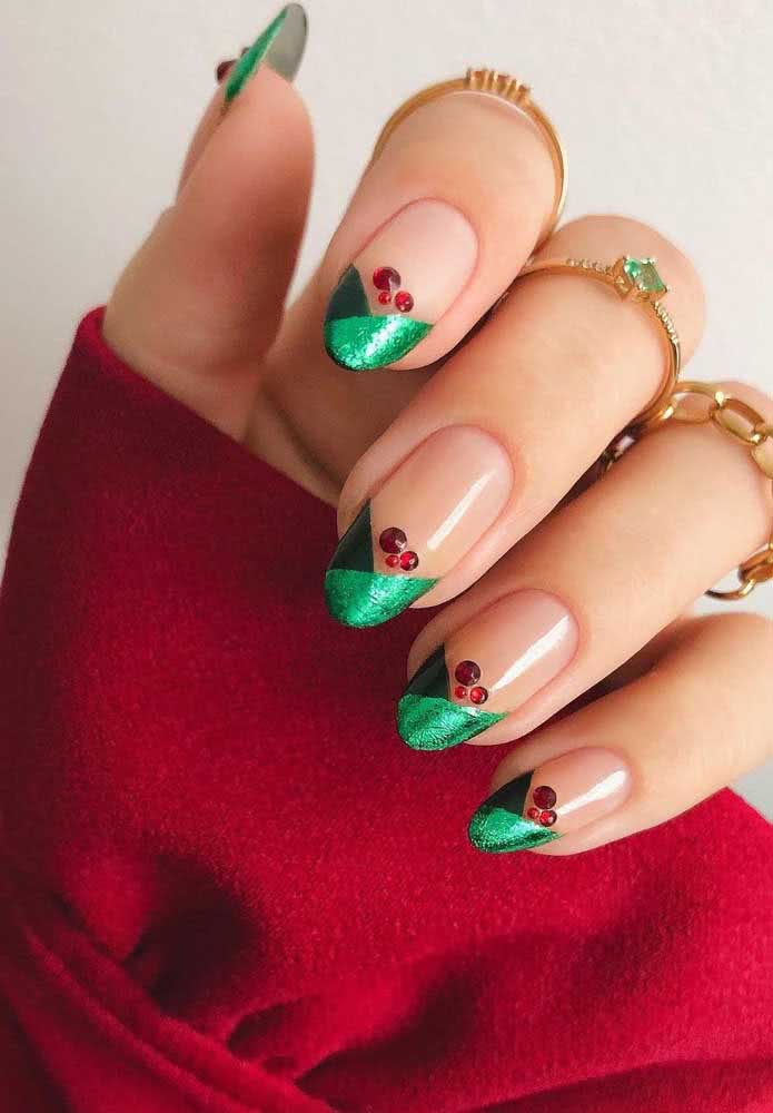 Uma francesinha geométrica e diferente com esmalte verde ganha o toque final com pedrinhas vermelhas, um visual perfeito para o natal. 